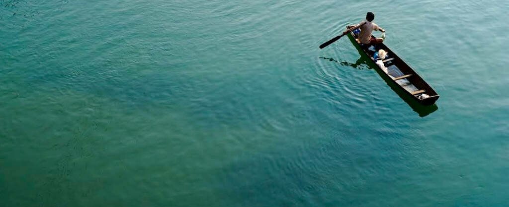 A fisherman on the Nam Lik River. The Nam Ngum Dam on the Nam Ngum River controls flow as it joins the Nam Lik River and eventually flows into the Mekong River further downstream.